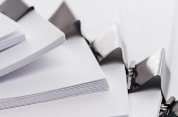 panoramic shot of stacks of blank paper with metal binder clips