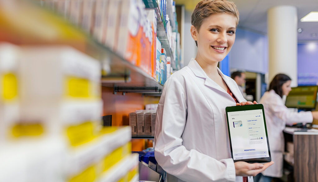 Portrait of smiling pharmacist in pharmacy holding tablet with digital order
